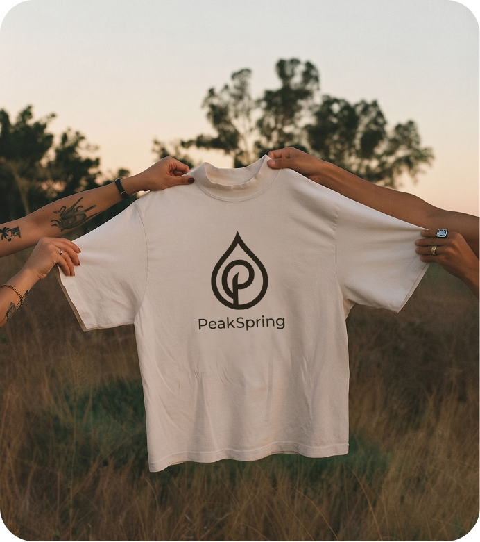 PeakSpring t-shirt with the droplet brandmark, held up outdoors